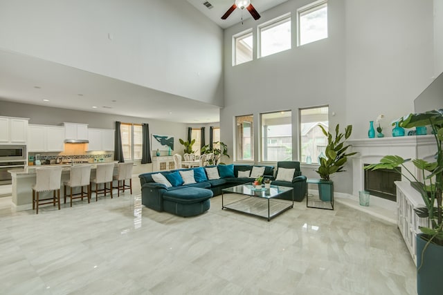 living room with light tile patterned flooring, a high ceiling, and ceiling fan