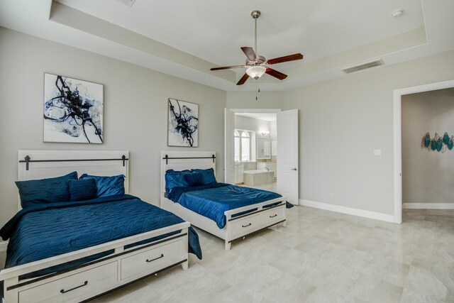 bedroom with connected bathroom, a raised ceiling, light tile patterned floors, and ceiling fan