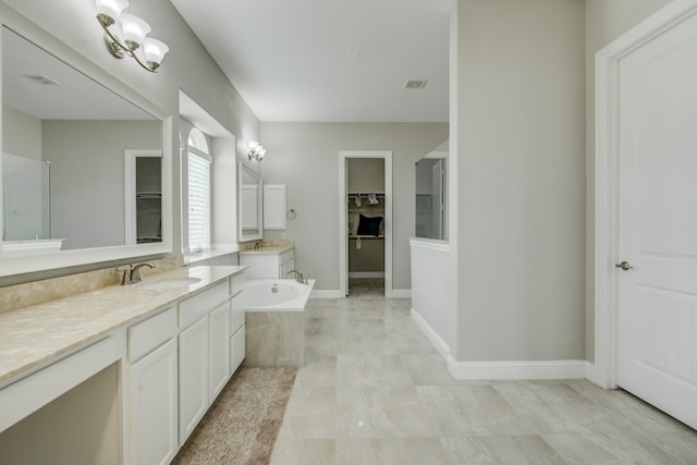 bathroom featuring tile patterned flooring, double vanity, a bath, and a notable chandelier