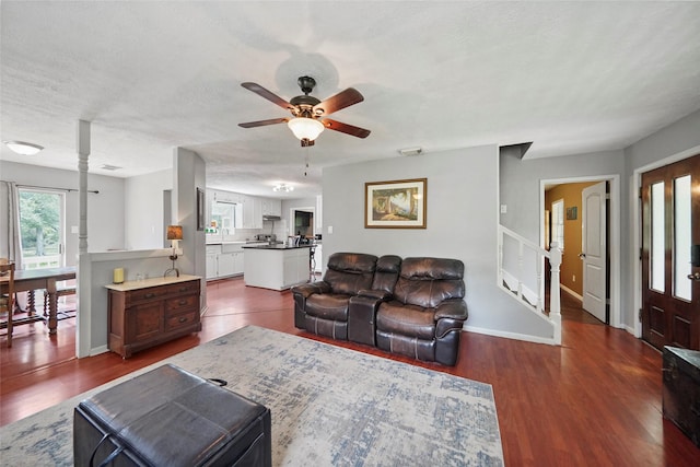 living room with ceiling fan, dark hardwood / wood-style floors, and a textured ceiling