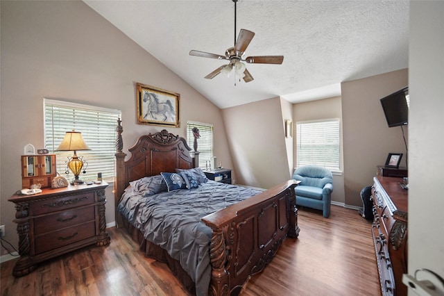 bedroom with vaulted ceiling, dark wood-type flooring, ceiling fan, and a textured ceiling