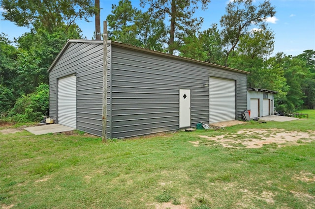 view of outdoor structure with a yard and a garage