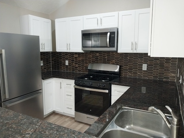 kitchen featuring sink, white cabinets, appliances with stainless steel finishes, and dark stone countertops