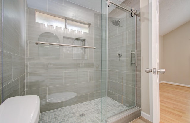 bathroom with a shower with door and hardwood / wood-style flooring