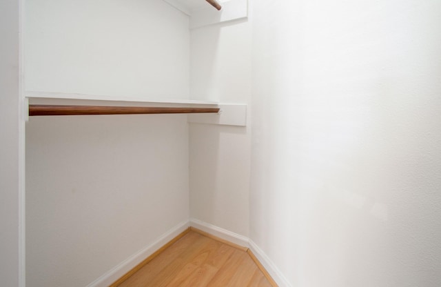 walk in closet with hardwood / wood-style flooring