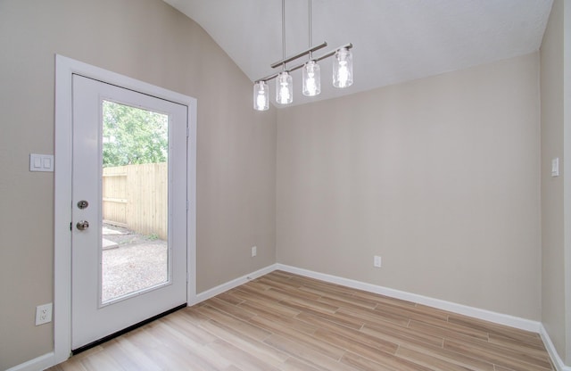 unfurnished dining area with light hardwood / wood-style floors and vaulted ceiling