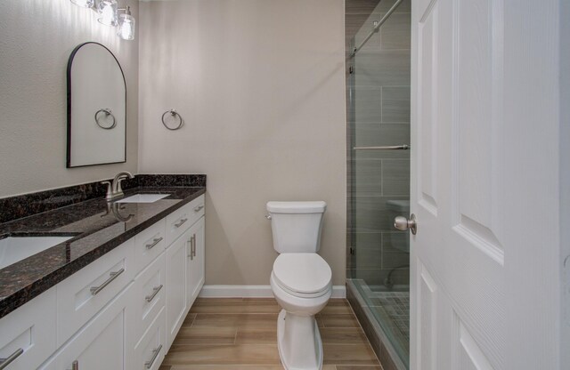 bathroom with tiled shower, toilet, and vanity