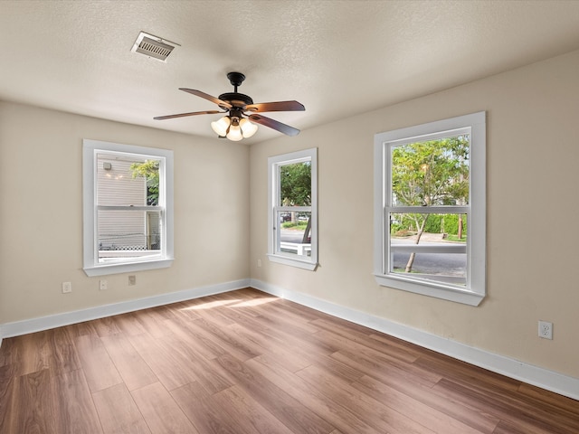 unfurnished room featuring ceiling fan, a textured ceiling, and light wood-type flooring