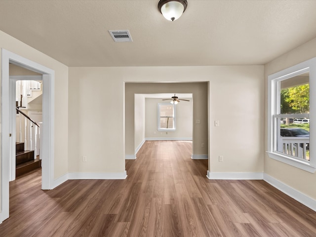 hallway with a textured ceiling and hardwood / wood-style flooring