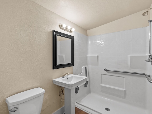 bathroom with toilet, lofted ceiling, a textured ceiling, and walk in shower