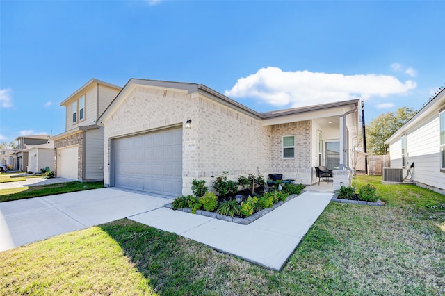 view of front of home with a garage, a front lawn, and central AC unit