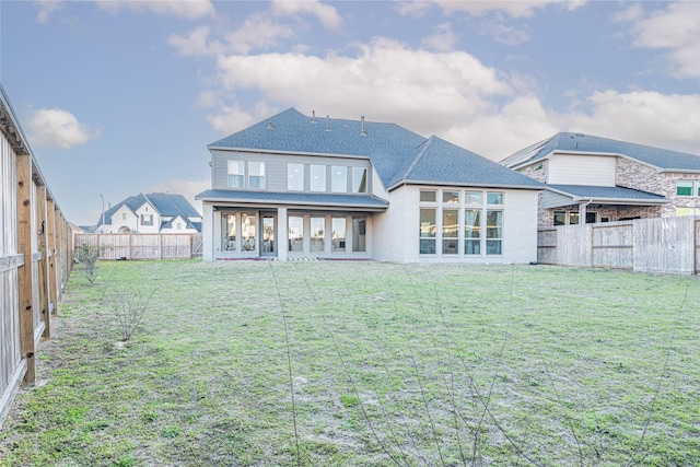 rear view of house featuring a yard