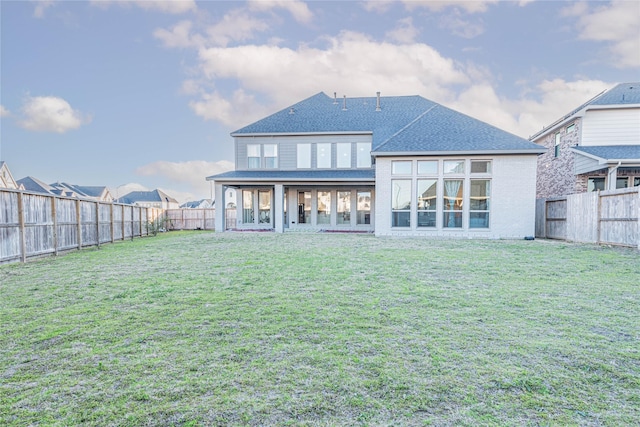 rear view of property featuring a lawn