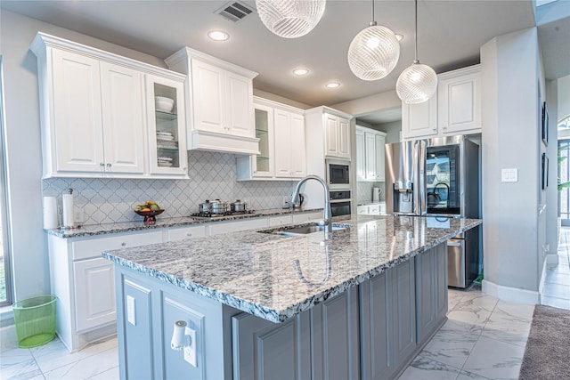 kitchen with white cabinetry, a center island with sink, sink, and appliances with stainless steel finishes