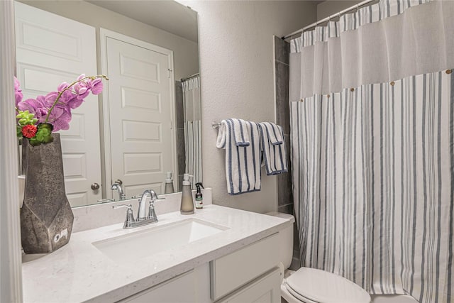 bathroom featuring a shower with shower curtain, vanity, and toilet