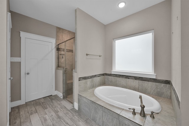 bathroom with wood-type flooring and independent shower and bath