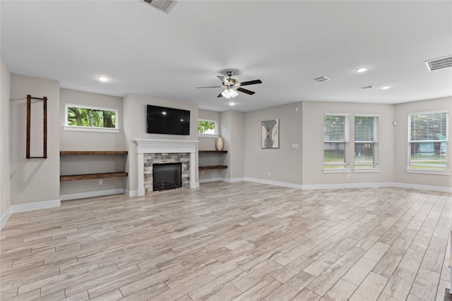 unfurnished living room featuring ceiling fan, light wood-type flooring, and a fireplace