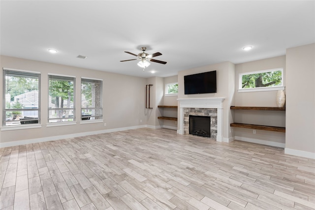 unfurnished living room with a fireplace, light wood-type flooring, and ceiling fan