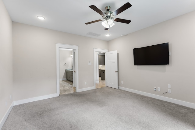 unfurnished bedroom with connected bathroom, ceiling fan, and light carpet