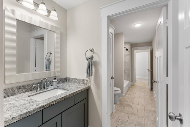 bathroom with tile patterned flooring, vanity, toilet, and walk in shower