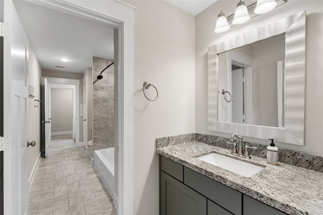 bathroom featuring vanity and tiled shower / bath