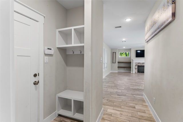 mudroom featuring a fireplace and light hardwood / wood-style floors