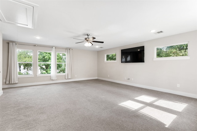 carpeted empty room with ceiling fan and a healthy amount of sunlight