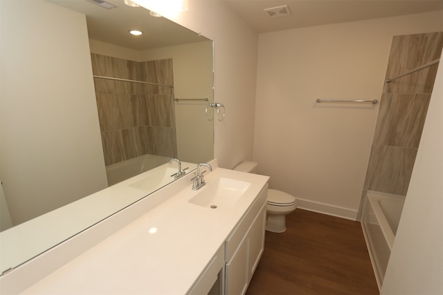 full bathroom with vanity, toilet, wood-type flooring, and tiled shower / bath