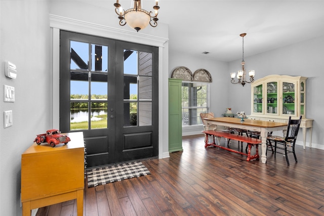 entryway with hardwood / wood-style floors and an inviting chandelier