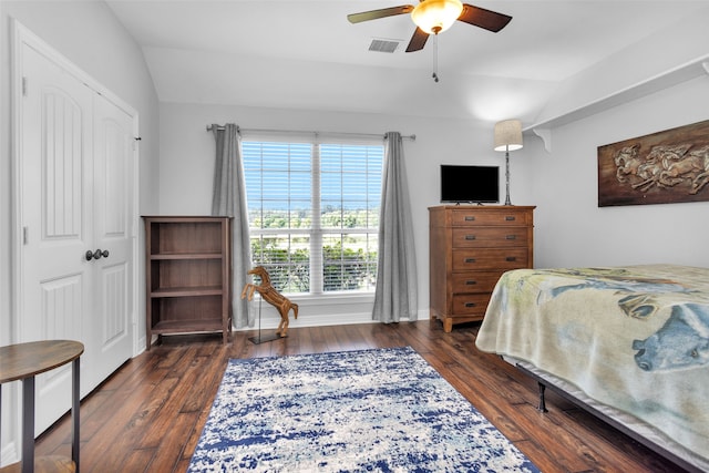 bedroom with dark wood-type flooring, vaulted ceiling, a closet, and ceiling fan