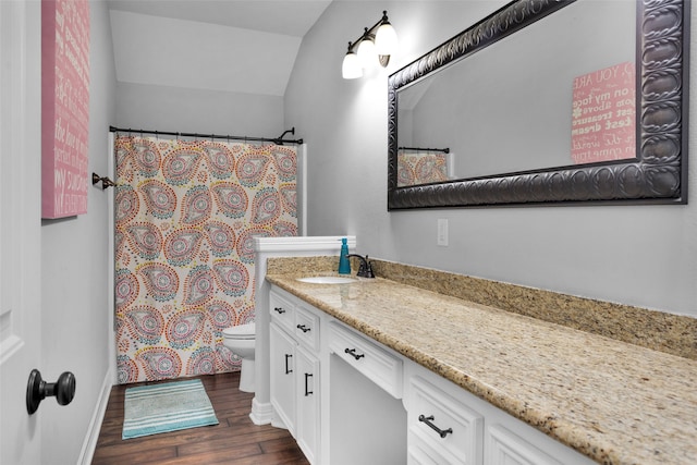 bathroom featuring hardwood / wood-style floors, vanity, vaulted ceiling, and toilet