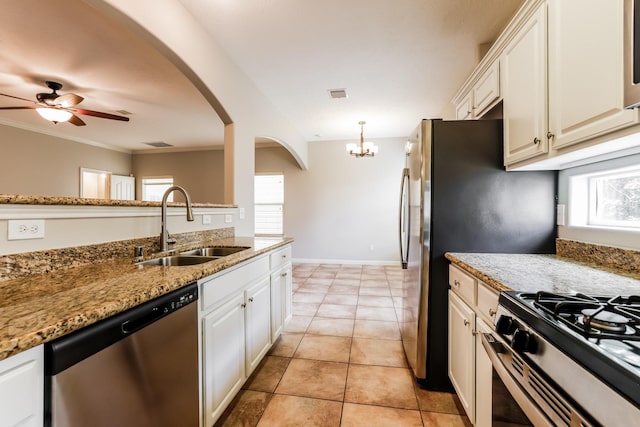 kitchen featuring ceiling fan with notable chandelier, appliances with stainless steel finishes, sink, light tile patterned flooring, and light stone counters