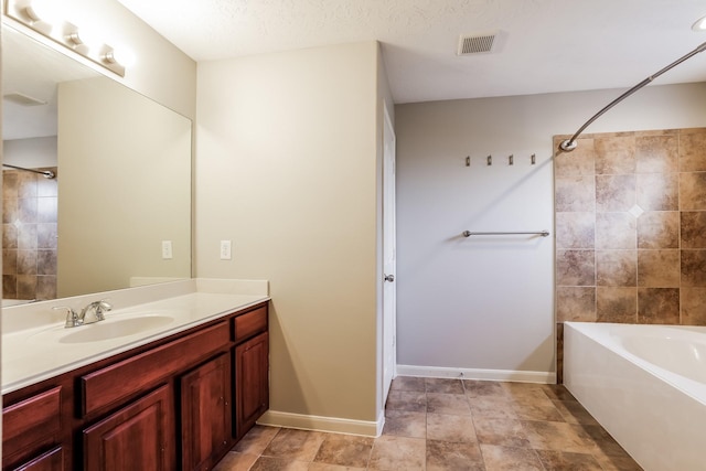 bathroom featuring shower / bath combination, vanity, and a textured ceiling