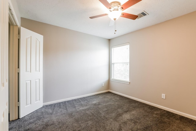 unfurnished room featuring ceiling fan and dark carpet