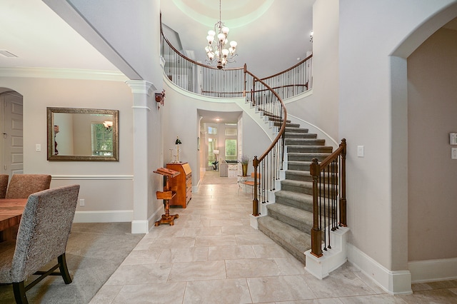 foyer featuring tile patterned floors, a chandelier, a wealth of natural light, and a towering ceiling