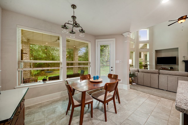 tiled dining space with ceiling fan with notable chandelier