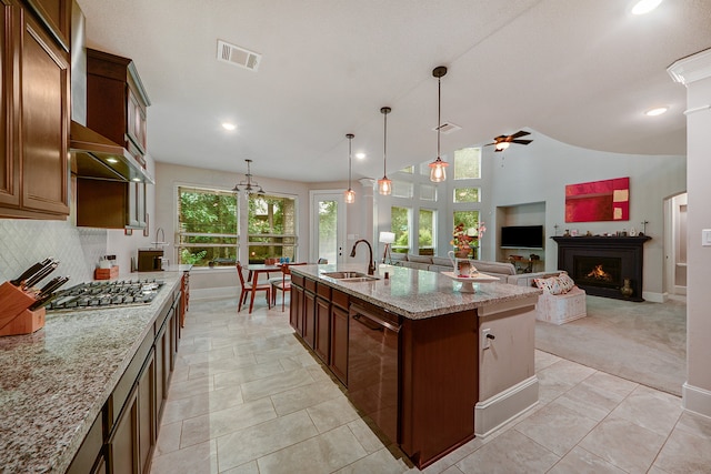 kitchen with stainless steel appliances, a center island with sink, sink, pendant lighting, and ceiling fan