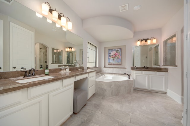 bathroom featuring a relaxing tiled tub, tile patterned flooring, and dual vanity