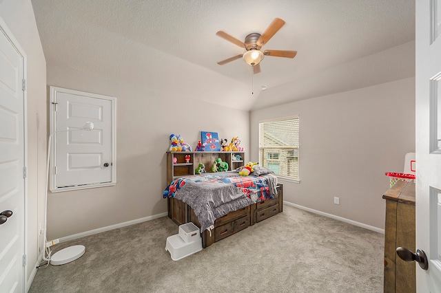 carpeted bedroom featuring a textured ceiling, vaulted ceiling, and ceiling fan