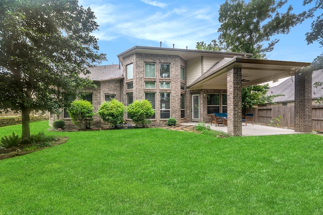 back of property with a patio area, ceiling fan, and a lawn