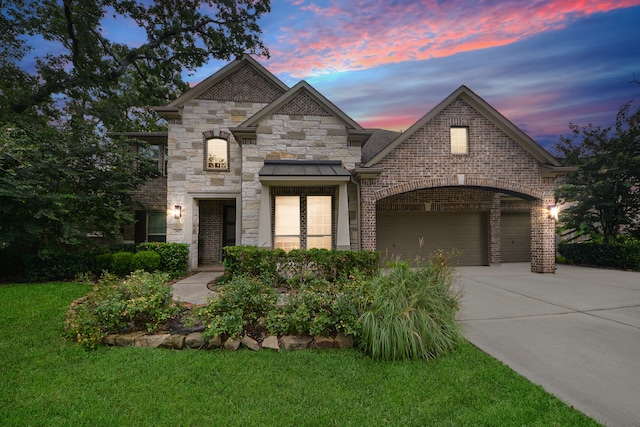 french country style house featuring a garage and a yard