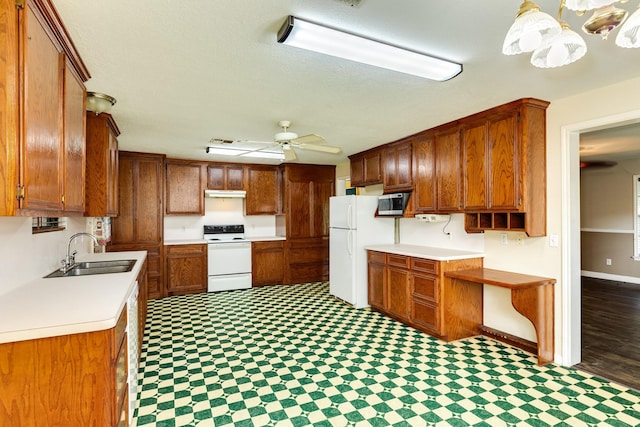 kitchen featuring ceiling fan, white appliances, hanging light fixtures, and sink