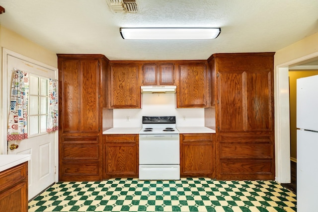 kitchen featuring a textured ceiling and white appliances