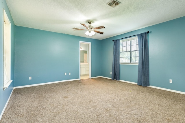 carpeted spare room with a textured ceiling and ceiling fan