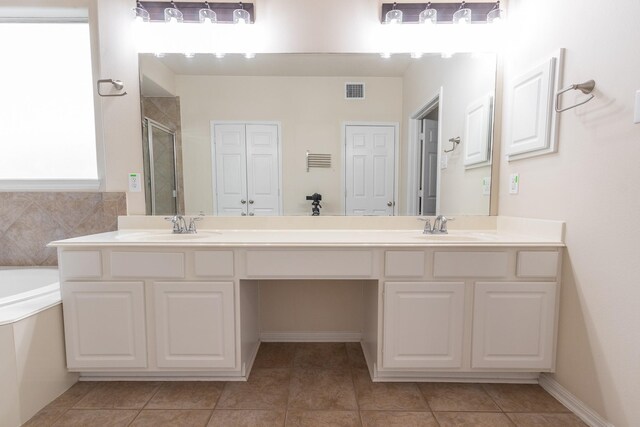 bathroom featuring dual vanity, independent shower and bath, and tile patterned floors