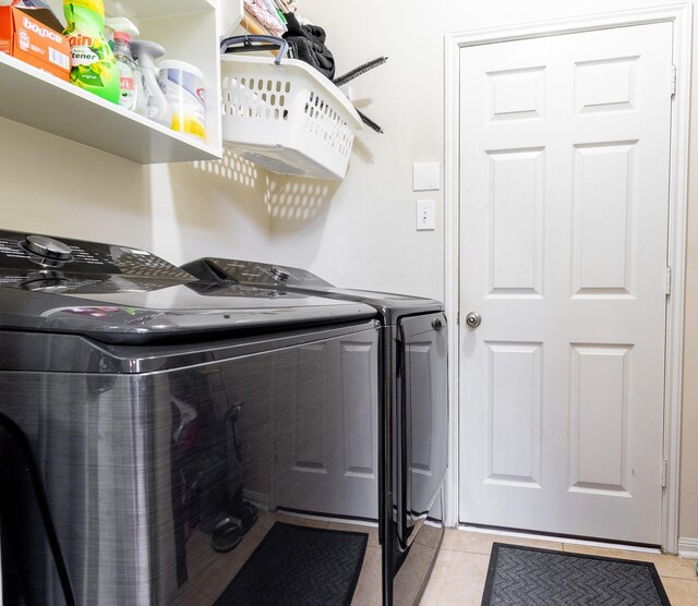 laundry area with washing machine and dryer and light tile patterned floors