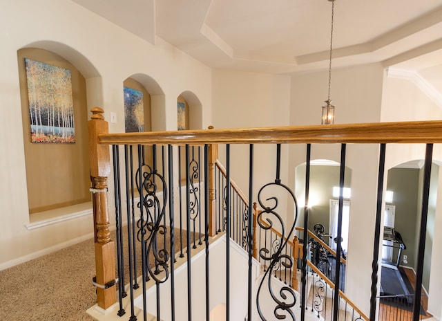 hall with carpet floors and a tray ceiling