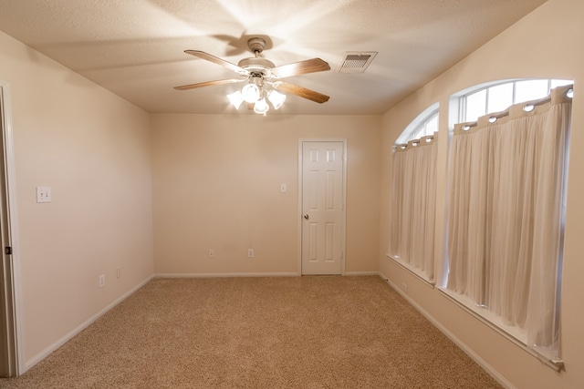 carpeted spare room with ceiling fan