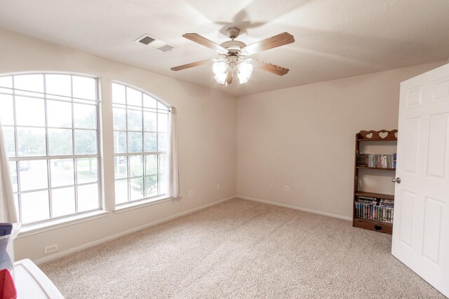 carpeted empty room featuring ceiling fan