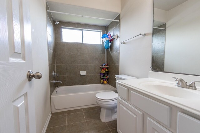 full bathroom featuring tile patterned flooring, toilet, vanity, and tiled shower / bath